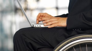 Businessman Sitting in a Wheelchair Working in a Laptop